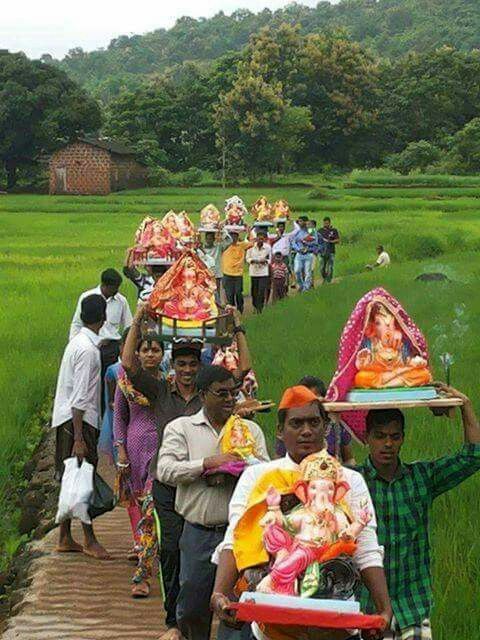Gauri-Ganpati procession crossing green fields in a Kokan village